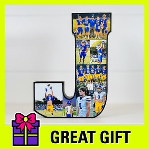 May include: A black wooden letter J with a collage of photos of people wearing blue and white football uniforms. The letter is standing on a white surface. The photos are arranged in a grid pattern. The letter is a great gift for a football fan.