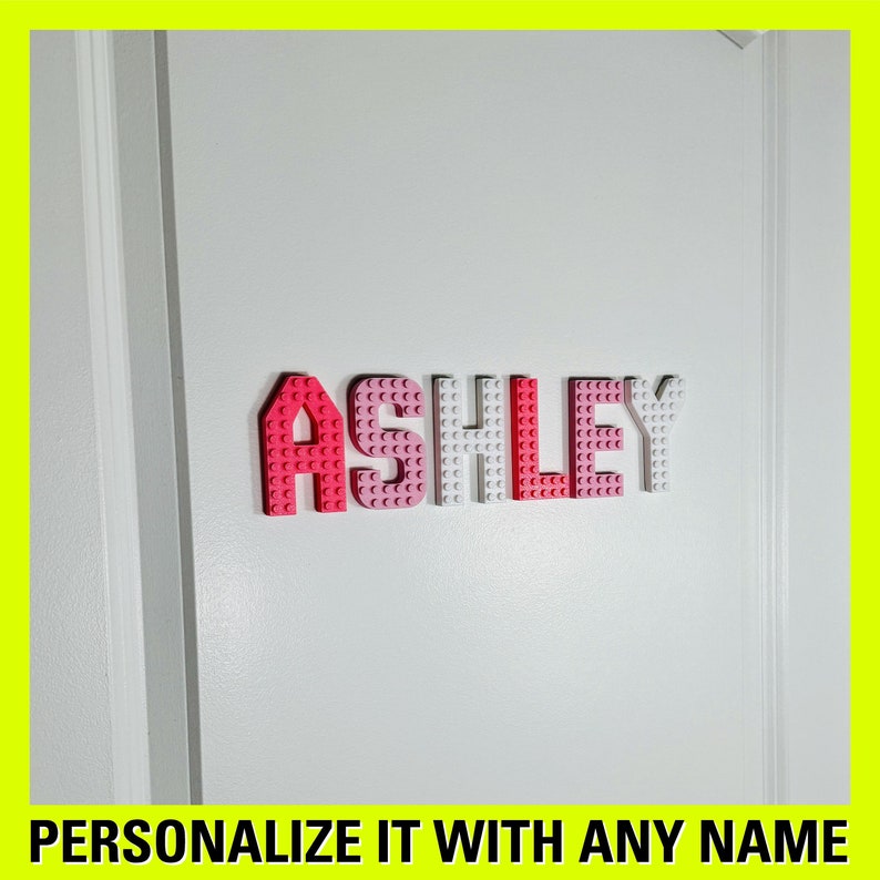 May include: A white door with the name "ASHLEY" spelled out in pink and white Lego bricks. The text "PERSONALIZE IT WITH ANY NAME" is at the bottom of the image.