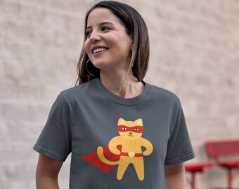 May include: A dark gray t-shirt with a cartoon illustration of a yellow cat wearing a red cape and mask. The cat is standing with its arms outstretched, as if in a superhero pose.