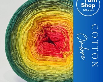 May include: A vibrant ball of ombre cotton yarn, transitioning from deep green to yellow, orange, and red. The yarn is labeled "Cotton Ombre" with a "Yarn Shop" logo in a blue rectangle. Ideal for knitting and crochet projects.