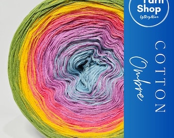 May include: A vibrant ball of cotton yarn in a rainbow of colors, including green, yellow, pink, and blue. The yarn is labeled "Ombre" and "Cotton" with the "Yarn Shop by StayAlive" logo. Ideal for knitting and crochet projects.