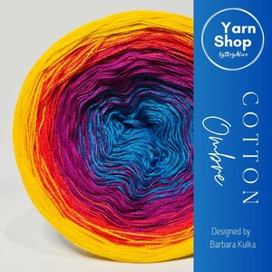 May include: A vibrant ball of ombre cotton yarn in shades of yellow, orange, red, purple, and blue. The yarn is labeled "Cotton Ombre" and "Yarn Shop by StayAlive", designed by Barbara Kulka.