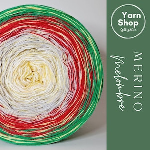 Pode incluir: Uma vibrante bola de fio Merino num padrão espiral, com faixas vermelhas, verdes, amarelas, brancas e cinzentas. O fio é rotulado como "Merino Melodrambe" com um logótipo "Yarn Shop".