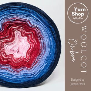 May include: A vibrant ball of Woolcot Ombre yarn, featuring a gradient of colors from deep navy blue to light pink. The yarn transitions through shades of red and lighter blues. The image includes the text "Yarn Shop by StayAlive".