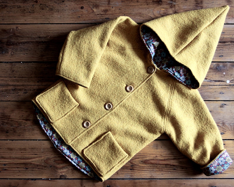 May include: A yellow hooded jacket with a floral patterned lining. The jacket has a button closure and two pockets.