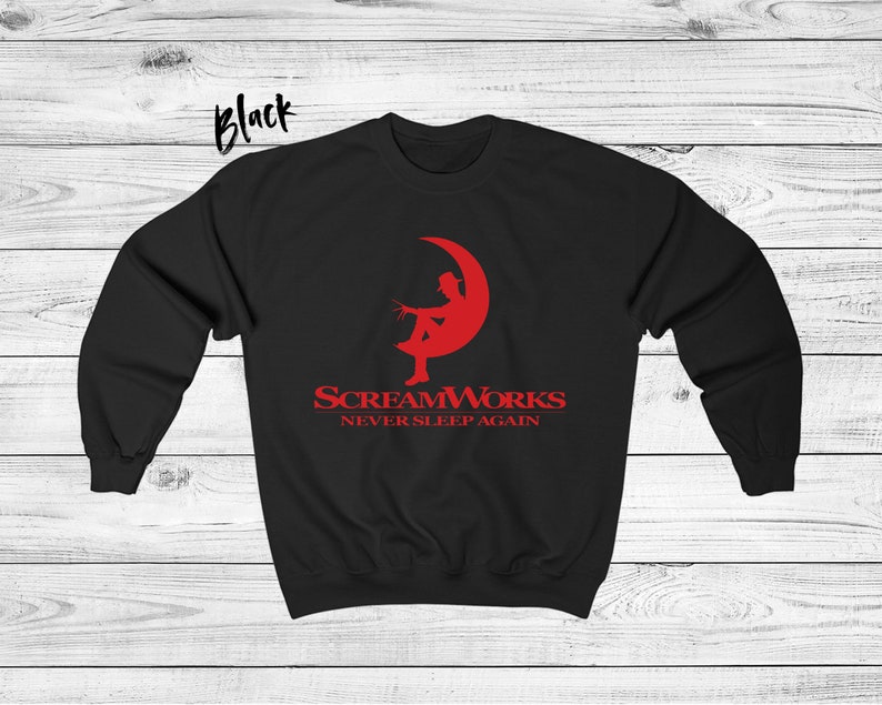 May include: Black sweatshirt with a red graphic of a person sitting on a crescent moon. The graphic says "ScreamWorks Never Sleep Again".