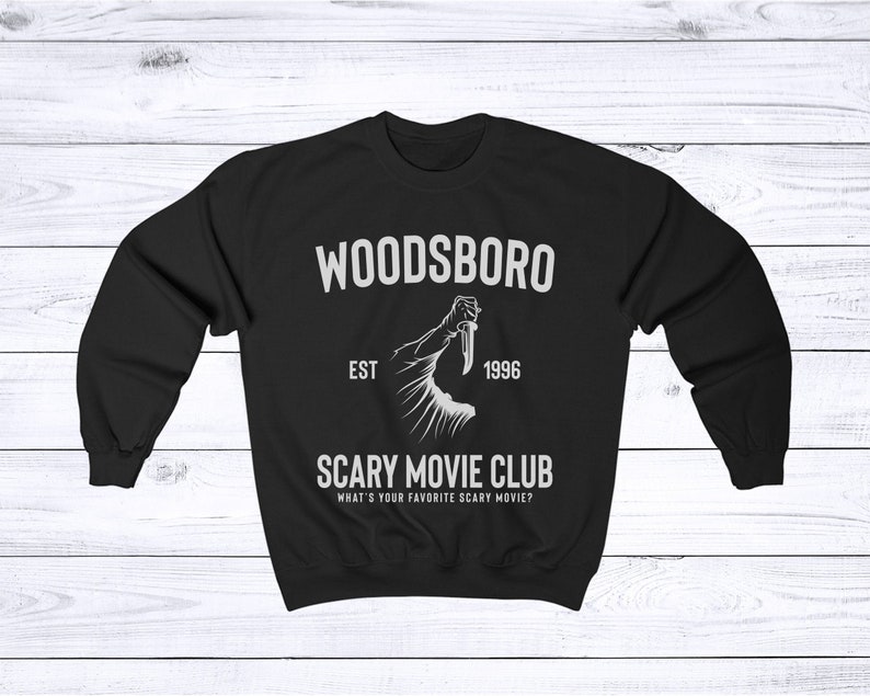 May include: Black sweatshirt with white text that reads "Woodsboro Est. 1996 Scary Movie Club What's your favorite scary movie?" and a graphic of a hand holding a knife.