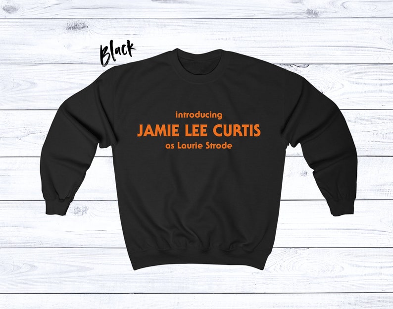 May include: Black sweatshirt with orange text that reads "introducing JAMIE LEE CURTIS as Laurie Strode".