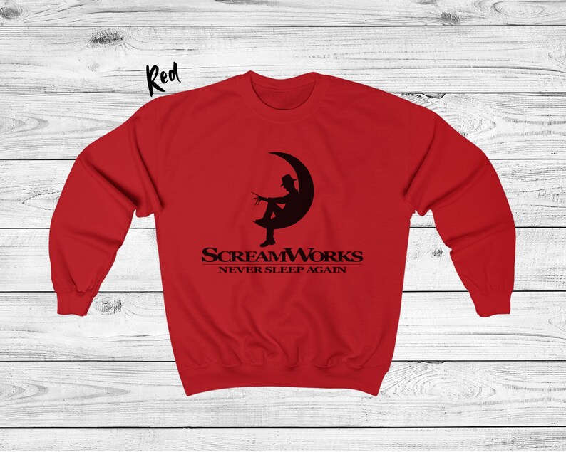 May include: Red sweatshirt with a black graphic of a person sitting on a crescent moon. The graphic includes the text "ScreamWorks Never Sleep Again".