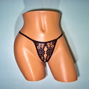 May include: Black lace lingerie with a floral design.