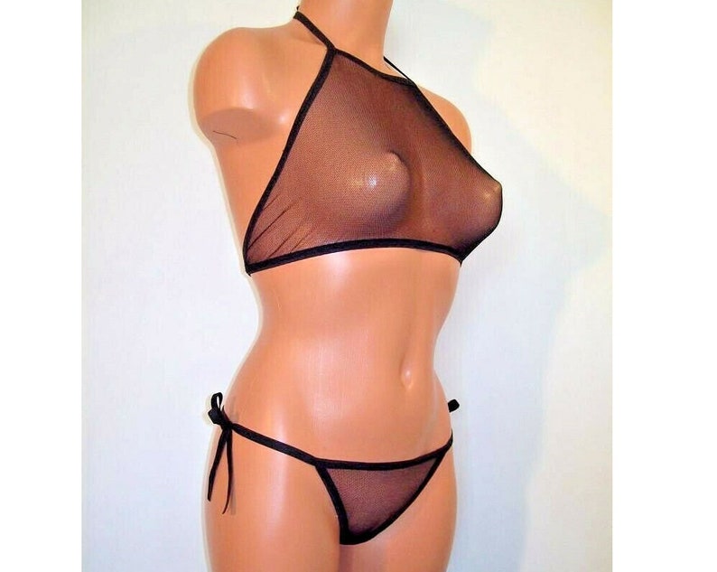 K&ouml;nnte beinhalten: Schwarzes Mesh-Halter-Top und passender Bikini-Slip mit seitlichem Bindeband. Das Oberteil hat einen hohen Ausschnitt und der Slip ist im Low-Rise-Stil.