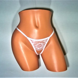 May include: White lace lingerie with thin straps and a delicate floral pattern.
