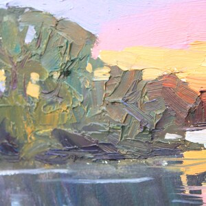 May include: Impressionistic oil painting of a landscape with a body of water reflecting the sky. The sky transitions from pink to yellow, suggesting a sunrise or sunset. Green and brown brushstrokes depict trees and land.