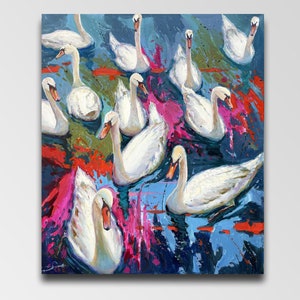 May include: A painting depicting a group of white swans swimming in a body of water. The water is painted in shades of blue, green, and pink, with splashes of red and white. The swans are arranged in a circular pattern, with their heads facing the centre of the circle.