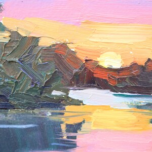 May include: Impasto oil painting of a sunset over a body of water. The sky transitions from pink to yellow, with the sun partially visible. Dark green and brown brushstrokes depict trees and land, reflecting in the water.