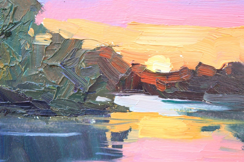 May include: Impasto oil painting of a sunset over a body of water. The sky transitions from pink to yellow, with the sun partially visible. Dark green and brown brushstrokes depict trees and land, reflecting in the water.