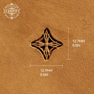 May include: A tan leather surface featuring a stamped four-pointed star design with intricate internal lines. The stamp measures 12.7mm by 12.7mm. The text STAMPIFY LEATHER STAMP CRAFT is visible in the upper left corner of the image.