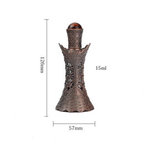 May include: A decorative bronze perfume bottle with a floral pattern. The bottle is 12.6cm tall, 5.7cm wide, and holds 15ml. It features a brown, rounded stopper. The design has a vintage feel.