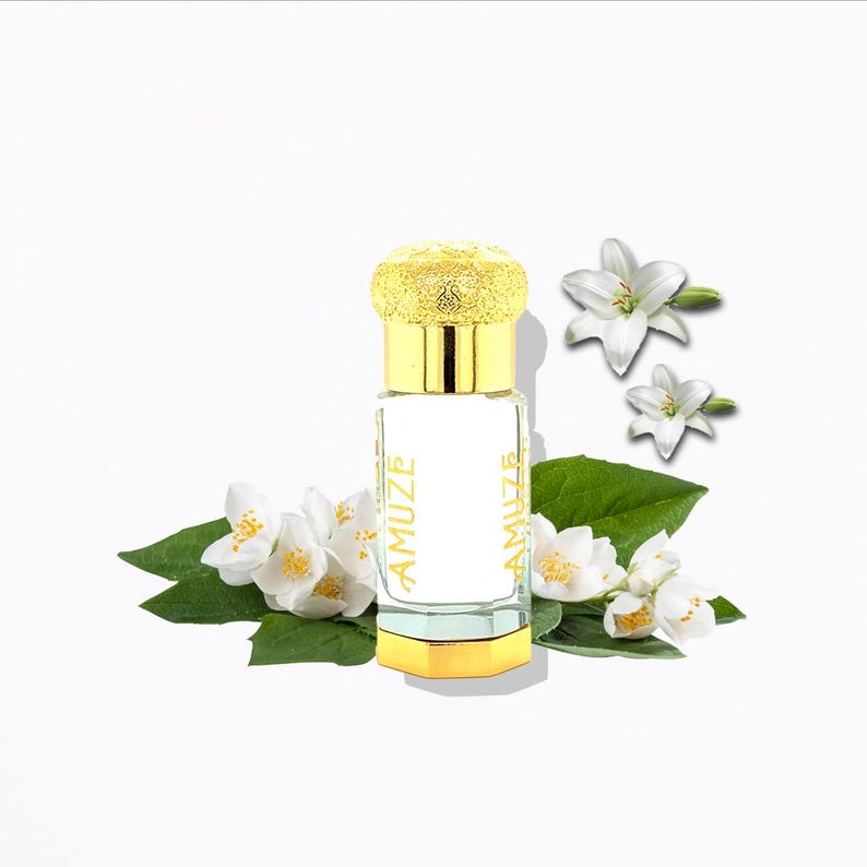 K&ouml;nnte beinhalten: Ein Parf&uuml;mflakon mit goldener Kappe und Boden, beschriftet mit "AMUZE" in goldfarbenen Buchstaben. Die Flasche ist von wei&szlig;en Jasminbl&uuml;ten, gr&uuml;nen Bl&auml;ttern und wei&szlig;en Lilien umgeben, alles vor einem wei&szlig;en Hintergrund.