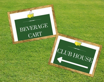 May include: Two wooden framed signs with green backgrounds and white text. The top sign says "BEVERAGE CART" and the bottom sign says "CLUB HOUSE" with an arrow pointing left. Both signs feature the Augusta National Golf Club logo.
