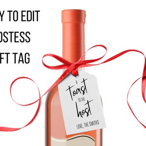 May include: A white gift tag with black text that reads "A toast to the host, Love, The Smiths" tied to a bottle of wine with a red ribbon.