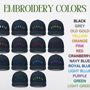 May include: A selection of 18 navy blue trucker hats with different colored embroidery. The embroidery says "PICNICLE" in a curved arc. The colors of the embroidery are white, black, grey, old gold, yellow, orange, pink, red, cranberry, navy blue, royal blue, light blue, purple, green, and light green.