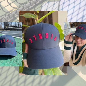 Könnte beinhalten: Eine marineblaue Baseballkappe mit dem roten, gestickten Wort "PICKLE" auf der Vorderseite. Die Kappe hat ein Netzrücken.