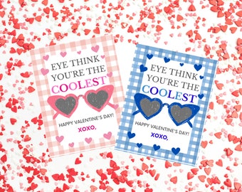 May include: Two Valentine's Day cards with a gingham pattern. The pink card says "EYE THINK YOU'RE THE COOLEST" with sunglasses and the blue card says "EYE THINK YOU'RE THE COOLEST" with sunglasses. Both cards say "HAPPY VALENTINE'S DAY! XOXO, "