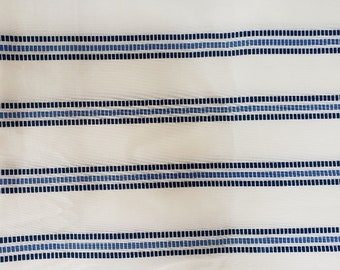 May include: White fabric with horizontal stripes of varying widths. The stripes alternate between solid blue and a pattern of small, dark blue squares. The fabric has a slightly sheer quality.