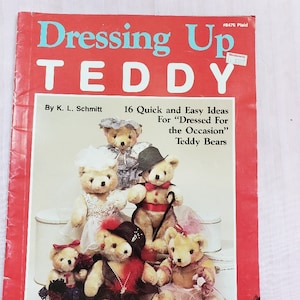 May include: A red book titled "Dressing Up TEDDY" with blue text, featuring illustrations of teddy bears in various outfits. The cover includes text by K. L. Schmitt and the subtitle "16 Quick and Easy Ideas For 'Dressed For the Occasion' Teddy Bears."