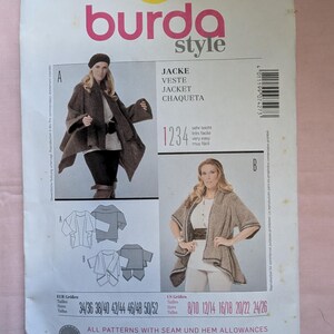 May include: Burda Style sewing pattern number 7427 for a jacket. The pattern includes sizes 34/36 to 50/52 and 8/10 to 24/26. The pattern is for a jacket with a shawl collar and a loose fit. The pattern includes seam and hem allowances. The text on the pattern says "All patterns with seam and hem allowances avec surplus de couture et d'ourlet con margenes para costura y dobladillos."