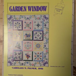May include: A yellow and white pattern pack for a quilt titled "Garden Window" by Carolann M. Palmer, 1992. The pack includes full-size patterns for 12 original blocks, a border, and step-by-step instructions. The quilt features appliqué flowers on pieced backgrounds. The finished size is 80 inches by 100 inches.