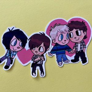 Puede incluir: Cuatro pegatinas de dibujos animados con figuras masculinas. Cada figura tiene ojos grandes y viste ropa informal. Dos figuras están frente a un corazón rosa. El fondo es amarillo liso.