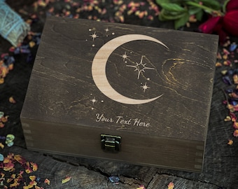 May include: A dark brown wooden box with a crescent moon and star design engraved on the lid. The box has a brass latch and the text "Your Text Here" is engraved below the design.