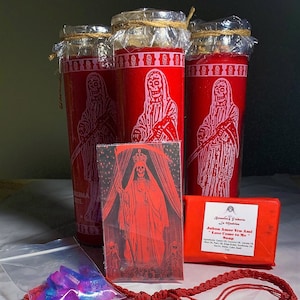 May include: A red candle with a skeletal figure holding a scythe, a card with a skeletal figure in a red robe, a red string necklace with a skeletal figure pendant, a small bag of purple crystals, and a red bar of soap with the text "Jabon Amor Ven Ami "Love Come to Me" Soap".