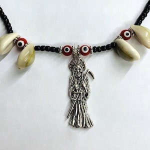May include: A black beaded necklace with red and white beads, a silver pendant of a skeleton figure holding a scythe, and white seashells with black eyes.