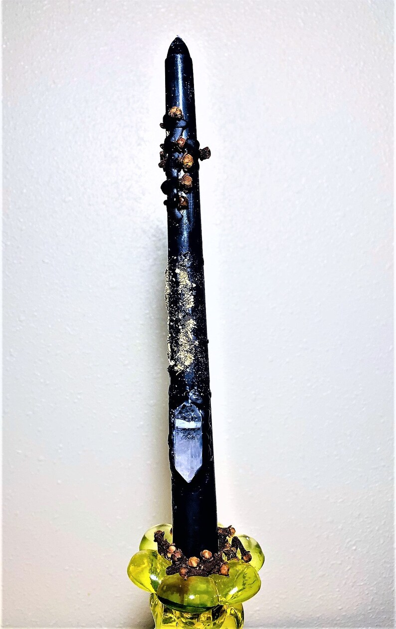 Peut inclure: Une bougie noire avec un cristal transparent incrust&eacute; sur le c&ocirc;t&eacute;, d&eacute;cor&eacute;e de clous de girofle et d'un bougeoir en verre jaune.