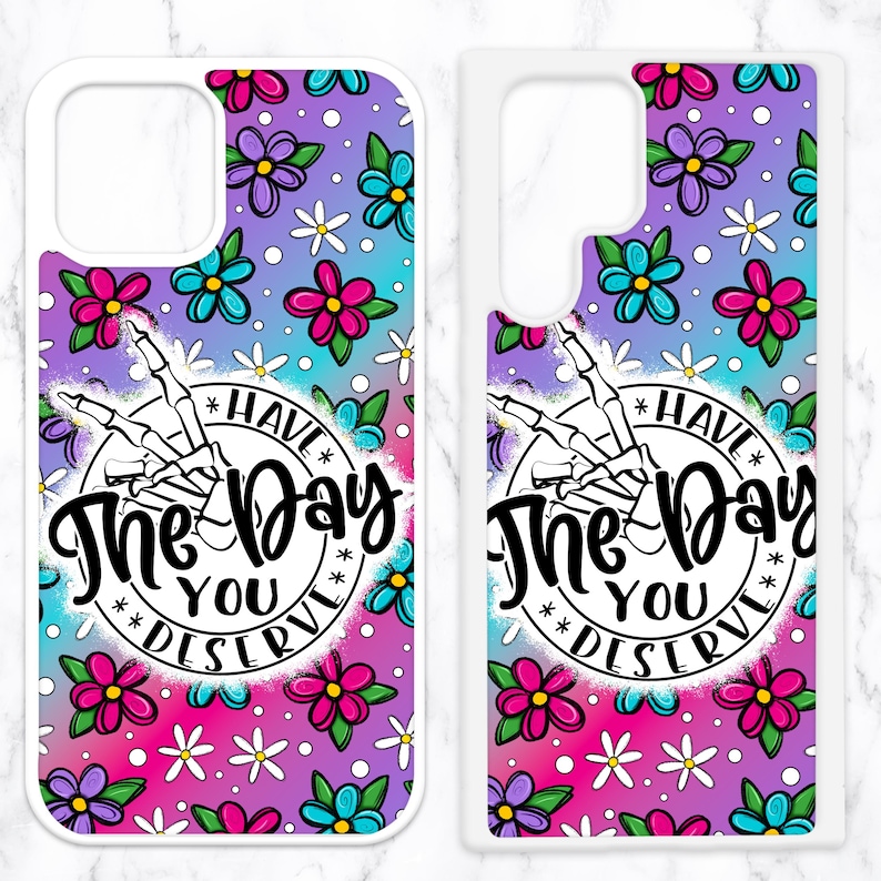 May include: Two white phone cases with a colorful floral pattern and the text "Have the day you deserve" in a circle with a skeleton hand.