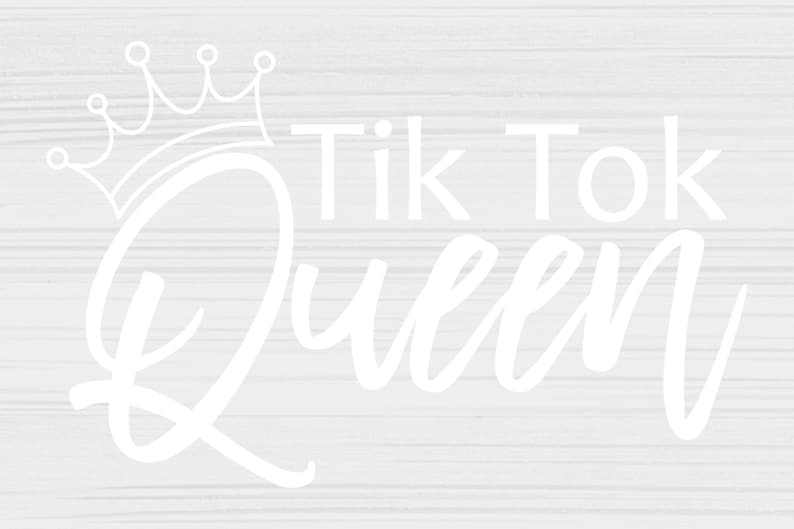 Pu&ograve; includere: Testo bianco su sfondo a grana di legno che recita "Tik Tok Queen" con una corona sopra la parola "Queen".
