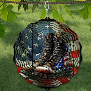 May include: A metal wind spinner with a red, white, and blue American flag design. The flag is draped over a pair of brown leather boots. The wind spinner is hanging from a hook.