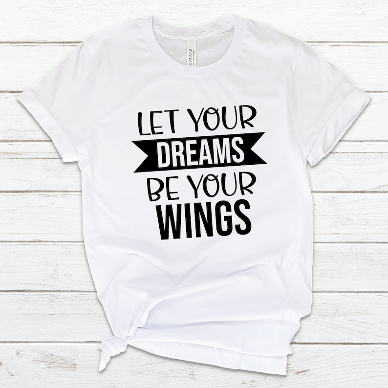 May include: White t-shirt with black text that reads "Let your dreams be your wings".