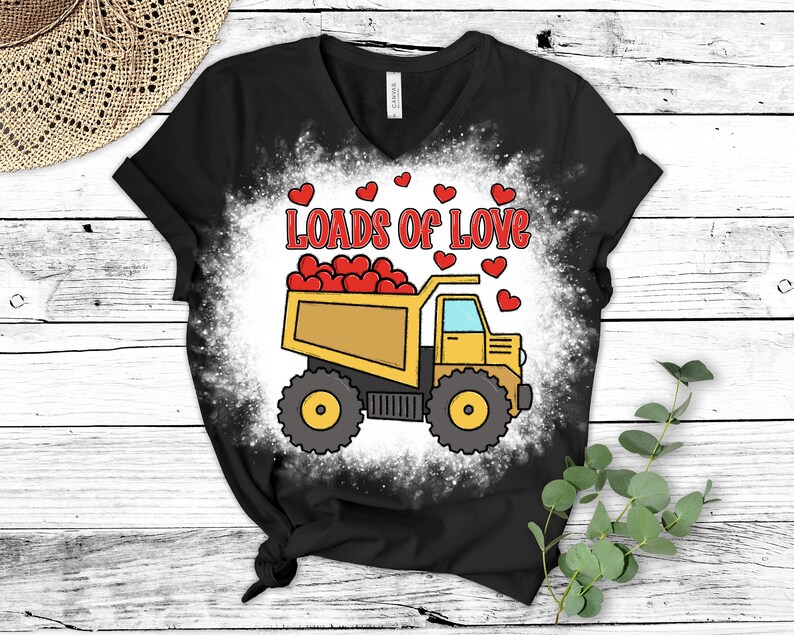 May include: A black t-shirt with a white bleach design of a yellow dump truck filled with red hearts. The text "Loads of Love" is above the truck.