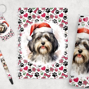 May include: A Christmas-themed gift set featuring a  watercolor illustration of a dog wearing a Santa hat. The set includes a tumbler, a notebook, a pen, and a keychain, all with a white background and a repeating pattern of paw prints, bones, hearts, and holly.