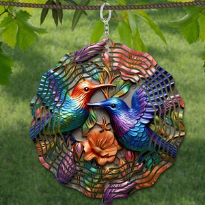 May include: A metal wind chime featuring two colorful hummingbirds in flight, surrounded by stylized flowers. The chime is suspended from a silver ring.