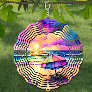 Peut inclure: Un mobile à vent en métal coloré représentant une scène de plage. Le mobile présente un coucher de soleil, des vagues océaniques et un parasol de plage. Les couleurs sont vives et comprennent le rose, le violet, le bleu, le jaune et l'orange.