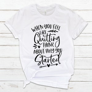 May include: White t-shirt with black text that reads "When you feel like quitting think about why you started" with a small arrow and hearts.