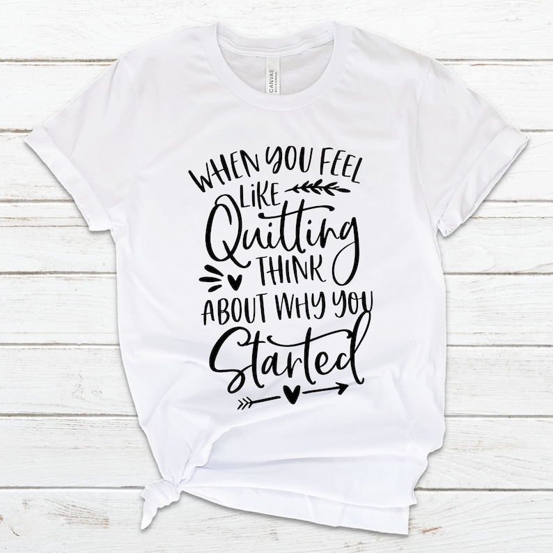 May include: White t-shirt with black text that reads "When you feel like quitting think about why you started" with a small arrow and hearts.