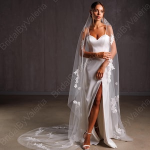 May include: A white wedding veil with delicate floral lace appliques. The veil is made of soft tulle and has a long, flowing train.