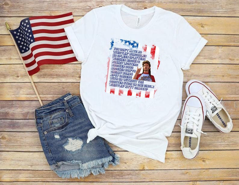 Op de afbeelding: Wit T-shirt met een afbeelding van een man en tekst in rood, wit en blauw. Het shirt wordt gecombineerd met een spijkerbroek, witte sneakers en een Amerikaanse vlag. De tekst op het shirt is een citaat.