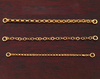 May include: Three gold chain extenders of different lengths, each with a lobster clasp on either end.